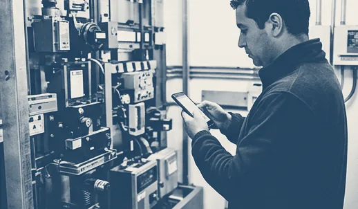 Técnico revisando un tablero eléctrico con una tablet en terreno