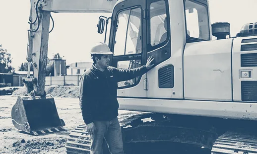 Operador junto a una excavadora en una obra
